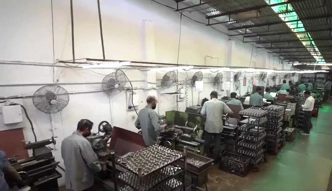 A long line of machines with operators on the Jolly Auto India shop floor