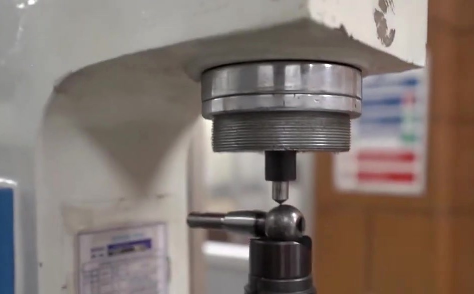 Hardness testing machine with a test sample under the indenter